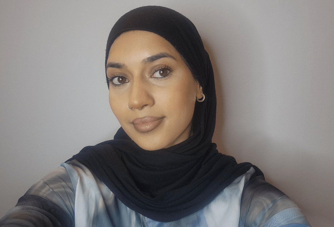 A young South Asian women wearing a black head scarf - looking ahead